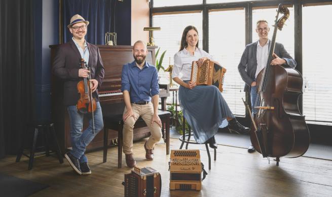 Well I have to say that these look like a jaunty group, four people sat or stood in a warm looking room with their folk instruments