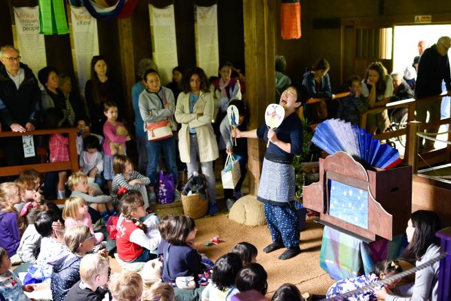 A person in traditional Japanese dress performing paper theatre