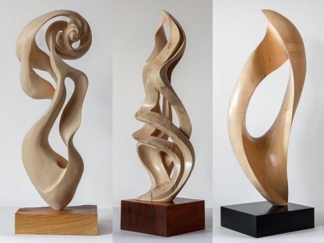 Three abstract sculptures made from wood.