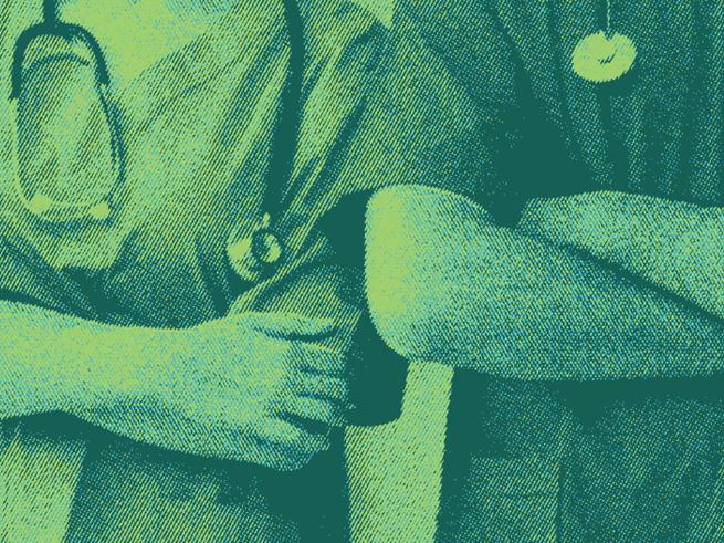 Two individuals in doctors scrubs with their arms crossed.