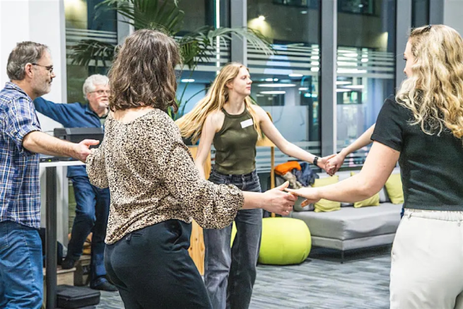 The picture is of a group of people laughing and dancing around, having fun.