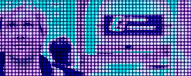 A stylised digital image with a dot matrix-like overlay, resembling a large LED screen. On the left, a person’s face is visible, with an individual behind them looking away, while the right side features abstract, curved shapes in vibrant teals and purples.