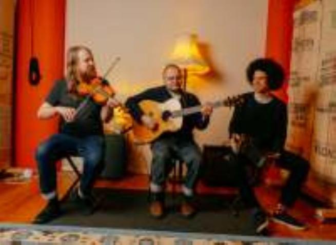 Three piece folk band with assorted facial hair. The overall distribution of hair between the three does seem somewhat unfiar mind.