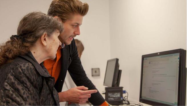 Man helping woman use the computer