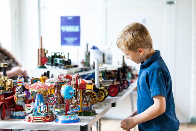 A young boy admiring a collection of vintage toys