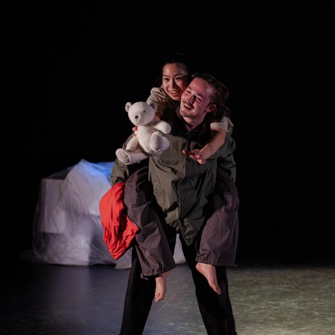 2 dancers on stage holding a polar bear teddy