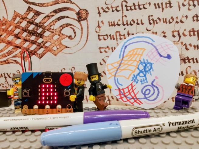 Lego mini-figures stand in front of Leeds's Royal Charter with a Micro:bit and felt tips