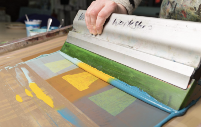 An image of plant pots being screen printed in shades of yellow and blue