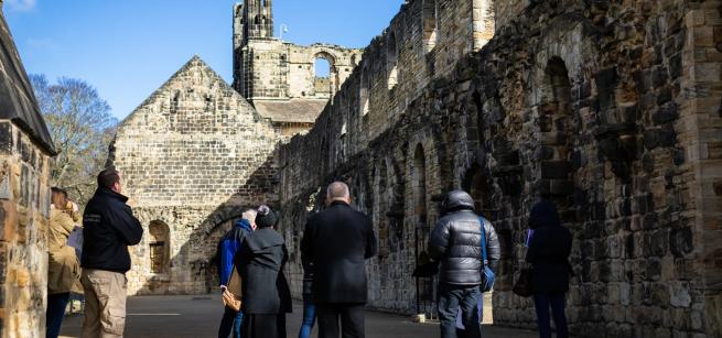 A group of people being toured around a Cistercian abbey 