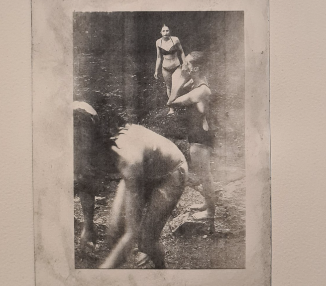 A photogravure print of women bathing in a river