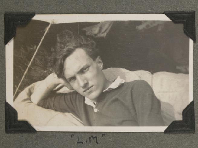 A black and white photo of a man resting his head on one hand.
