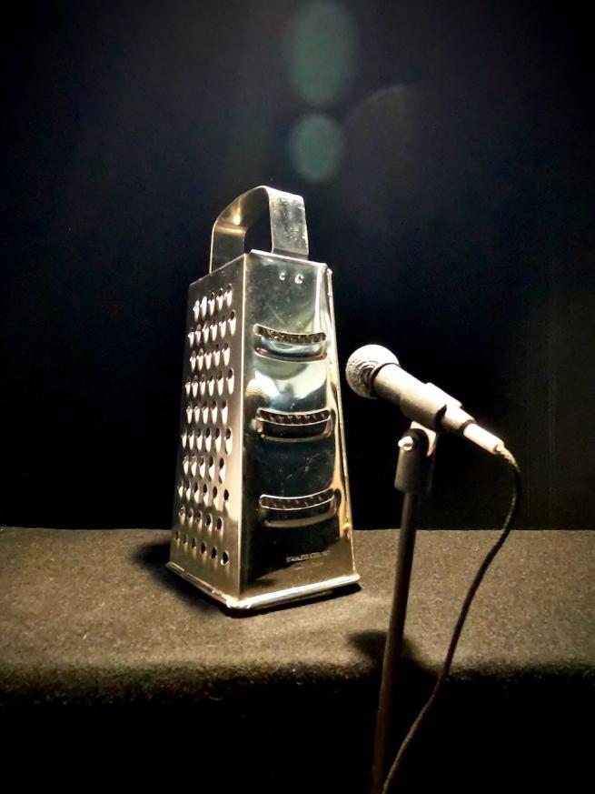 A cheese grater infront of a microphone