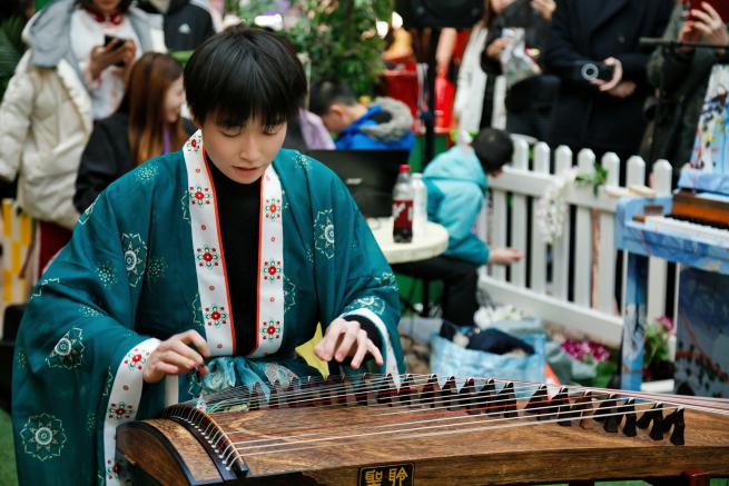 Mio and Guzheng, He is seated wearing traditional outfit