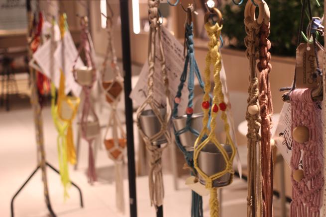 Image shows a clothes rail full of colourful plant hanger.