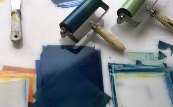 Ink rollers and inks being rolled on a white surface