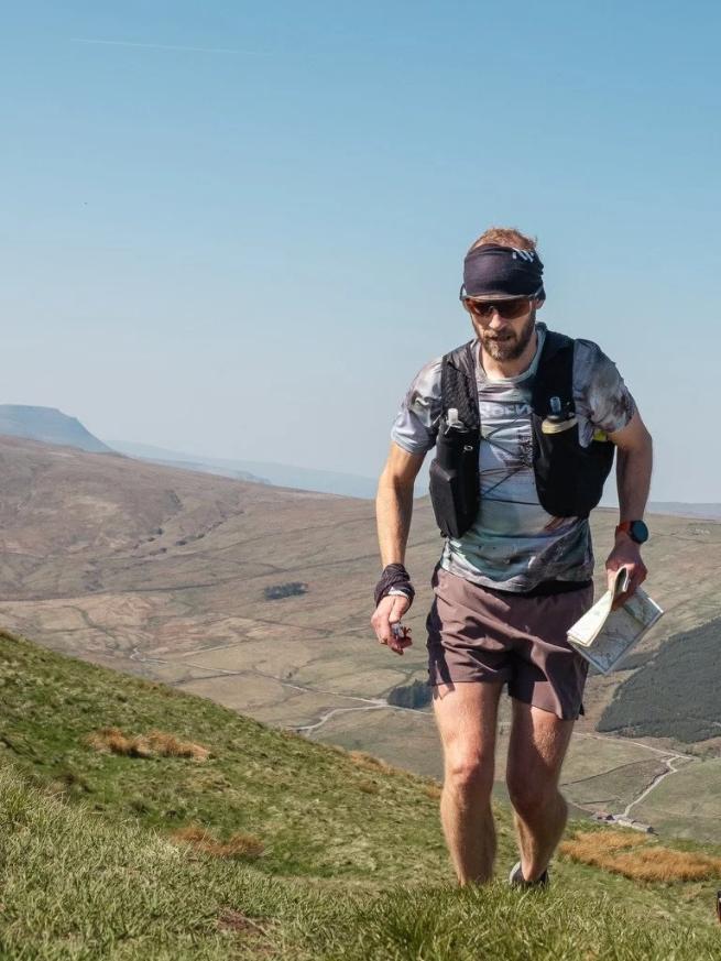 A man in running gear runs up the side of a mountain