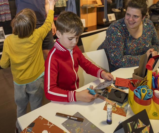 A group of people create something crafty in the M&S Archive exhibition