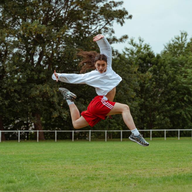 Dancer jumps in playing field
