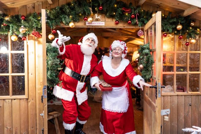 Photograph of two figures dressed as Father Christmas and Mrs Claus.