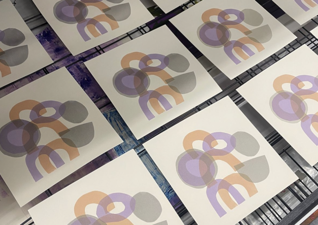 Abstract prints in greys, purples and oranges on a drying rack