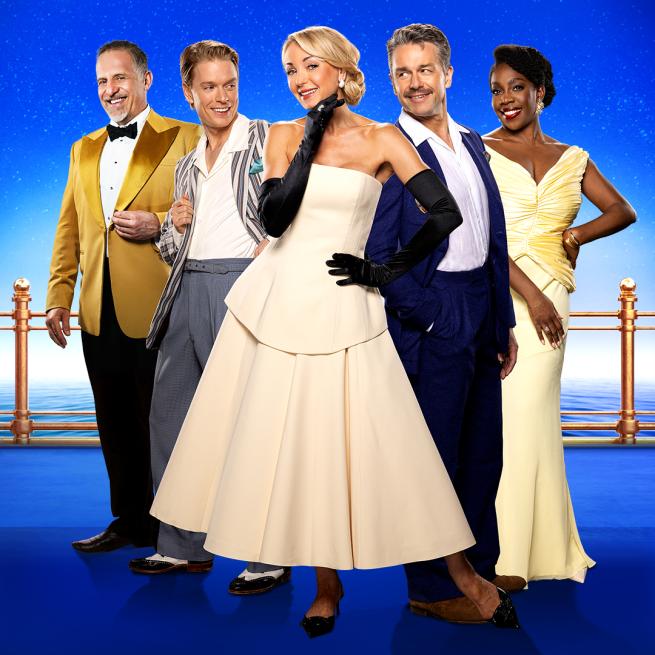 Helen George smiles in the centre, raising a gloved hand to her chin, flanked by Freddie Fox and Julian Ovenden who look at her from each side. Nigel Lindsay smiles on the left, and Carly Mercedes Dyer on the right, set against a starry blue backdrop.