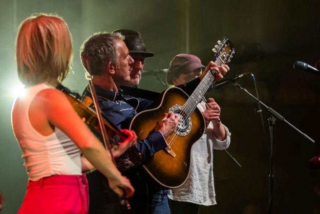 Group of musicians with guitar, fiddle and whistle
