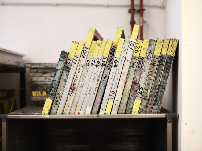 A range of different sized screen printing screens stacked on a shelf