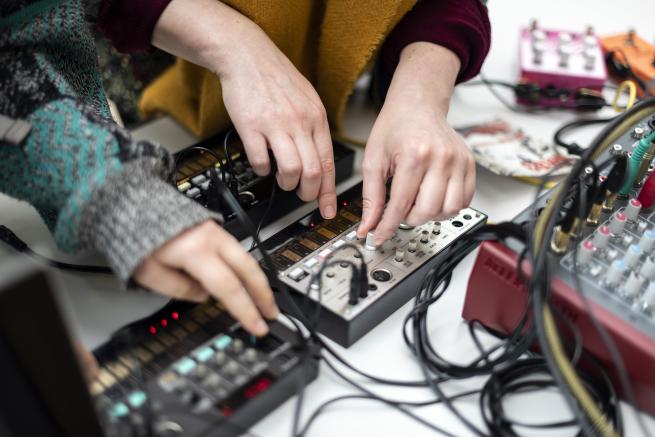 Two people using musical PA equipment 