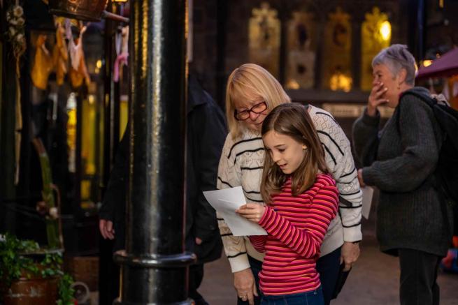 An adult and child looking at a trail in the victorian streets at Abbey House Museum