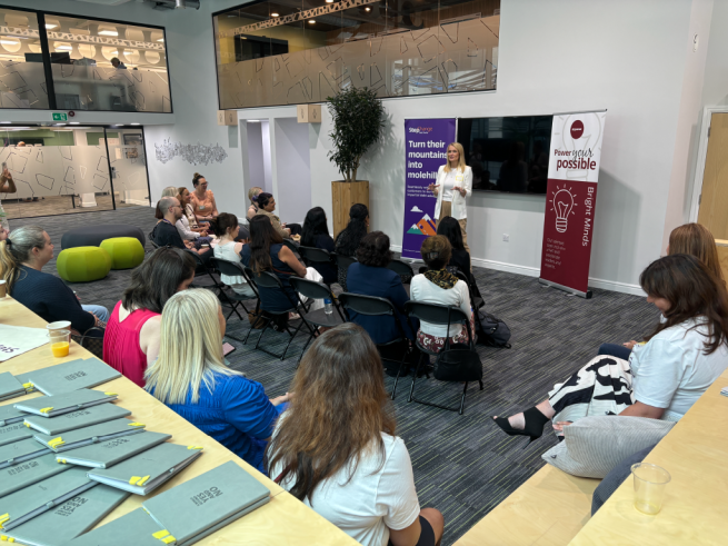 The picture is a group of people in Wellington Place listening to a speaker.