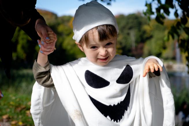 a toddler in a ghost costume