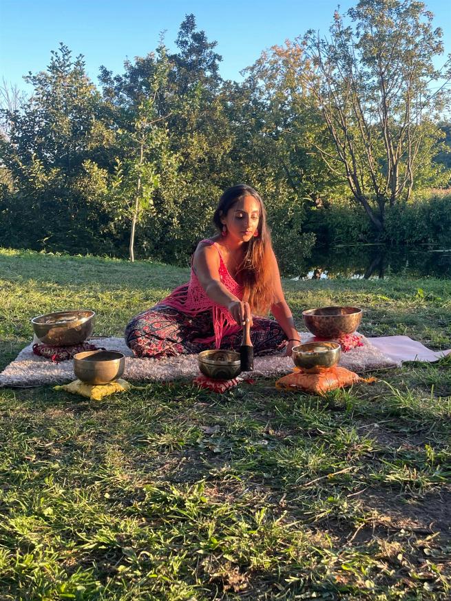 Neeta Sarl from sarl sound healing playing a Himalayan singing bowl in the sunshine