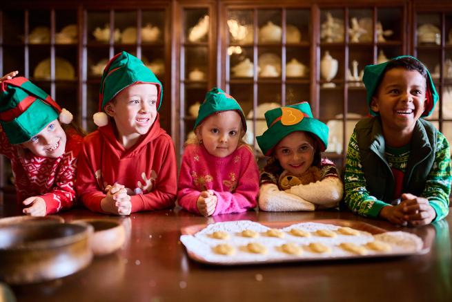 Photograph of a group of five children dressed as elves.
