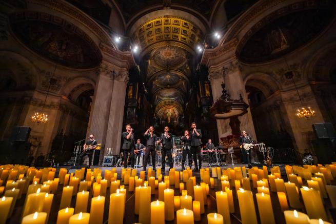 Live band performing in a stunning candlelit cathedral.