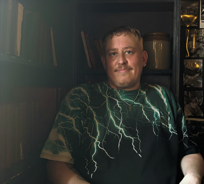 A man sat in a relatively dark room