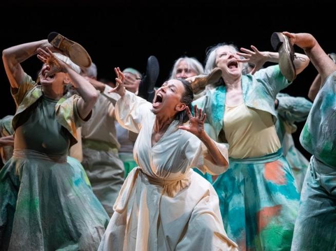 A group of older women writhe on stage as if screaming