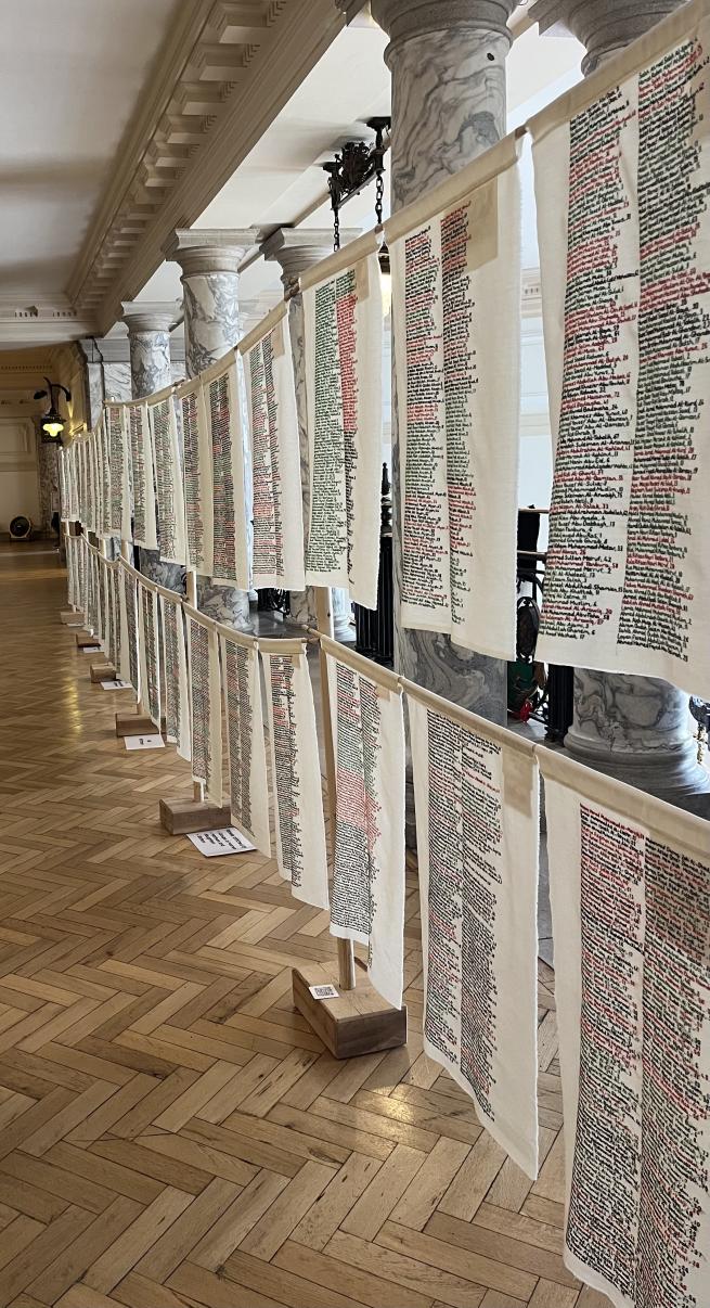 A row of fabric panels embroidered with names