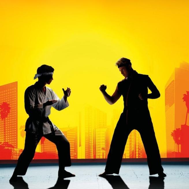 Two silhouettes hold competitive karate poses in front of a sunny cityscape.