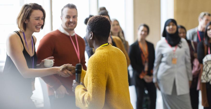 businesswoman-shaking-hands-with-speaker-at-conference