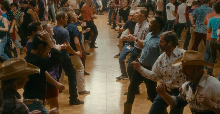 A large group of people face each other in a line dance