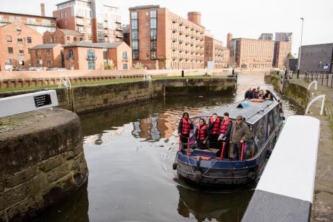 a canal boat on the river with buildings in the background