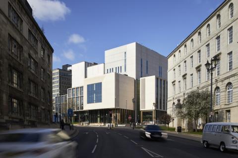 Large modern building at the end of a busy city road