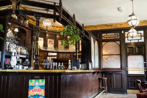 an old pub with wooden interiors and deocrative windows