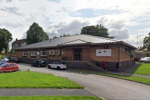 A sandy brick community centre on a council housing estate