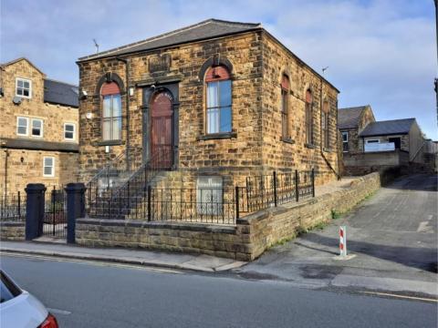 Image of the Morley labour rooms, a square stone building with a brown door.