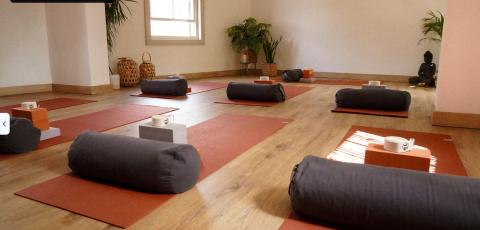 Inside of a yoga studio with mats and props laid out