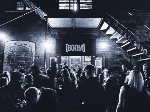a crowd of people inside a venue signposted boom