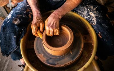 A lady at a pottery wheel making a ceramic pot