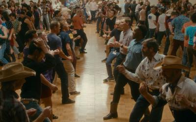 A large group of people face each other in a line dance