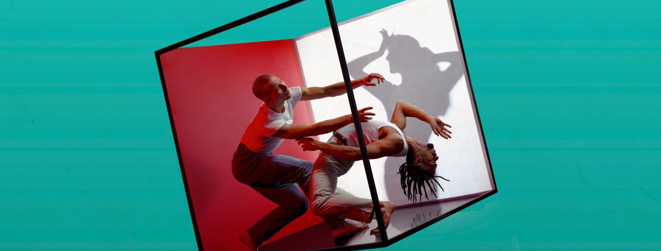 Two people dancing in a see-through box.